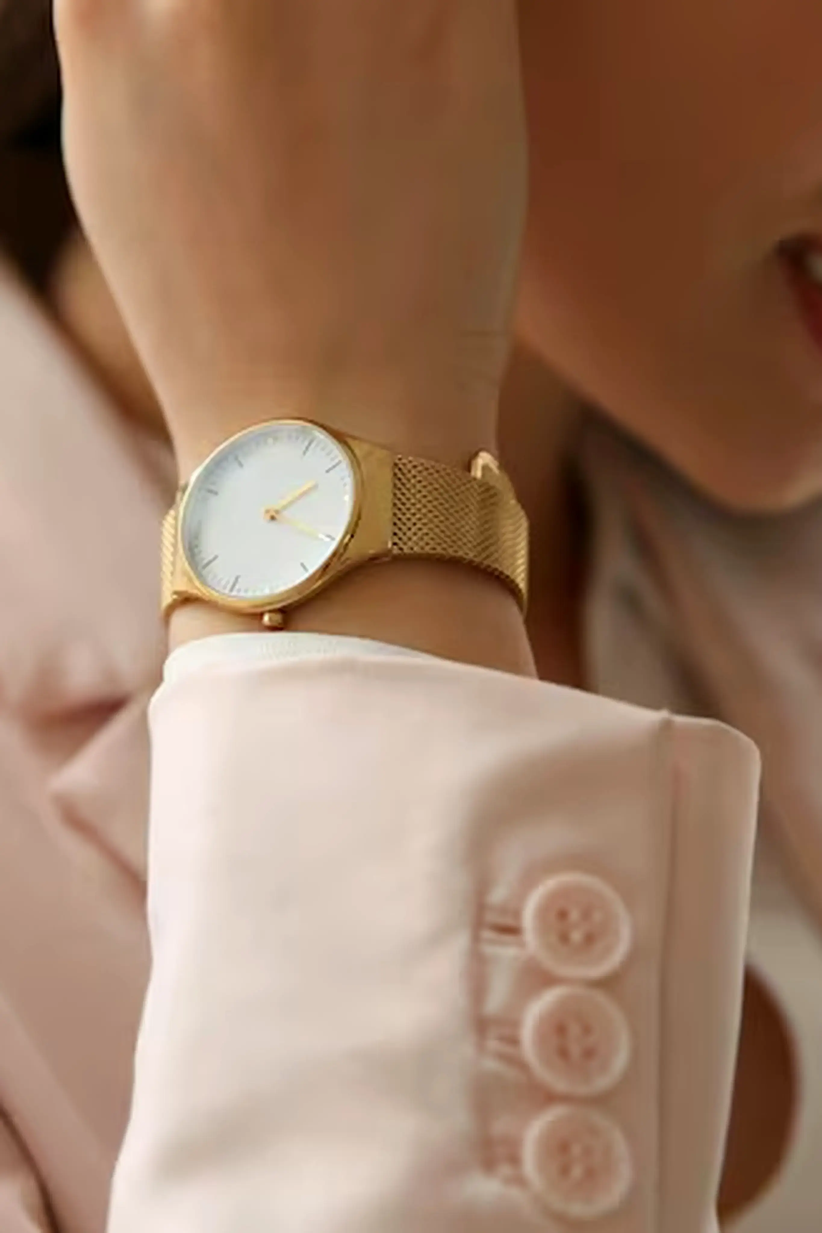 Femme portant une montre dorée